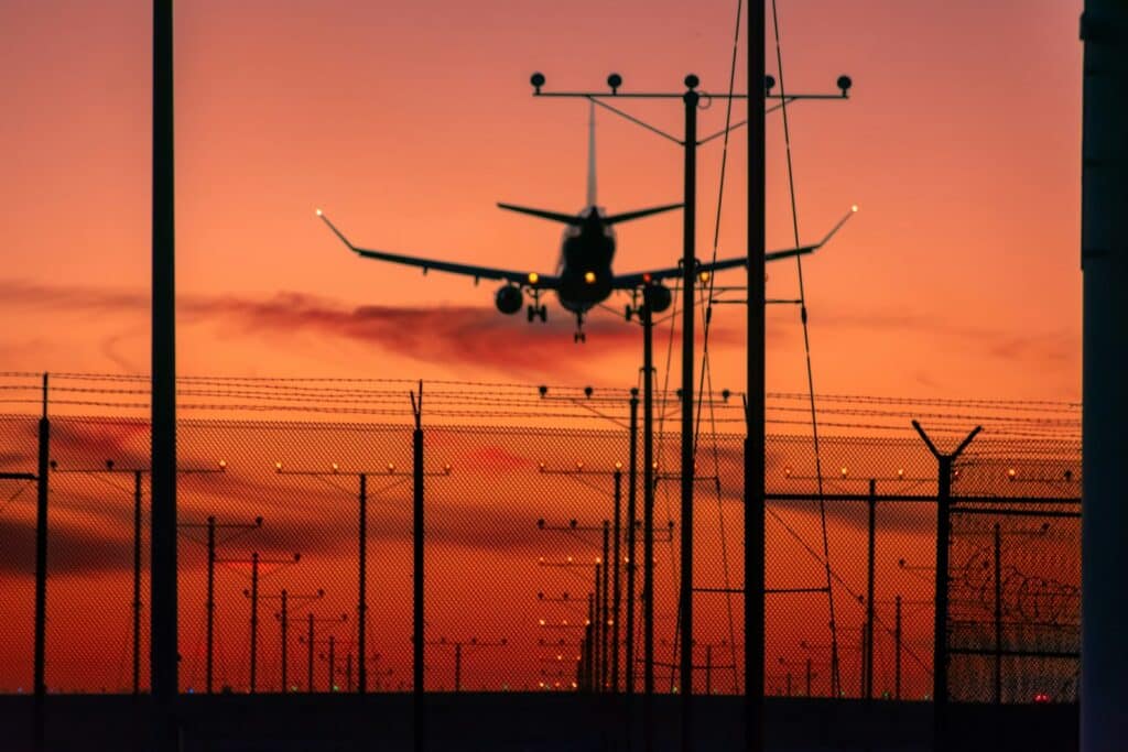 a plane is flying low over a fence